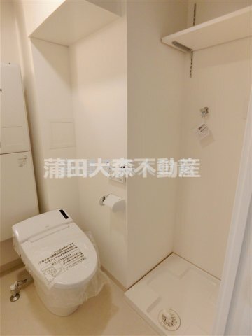 拡大写真:ミライズ平和島レジデンス 1階104の棚付きの洗濯機置き場 温水洗浄便座付きのタンクレストイレ